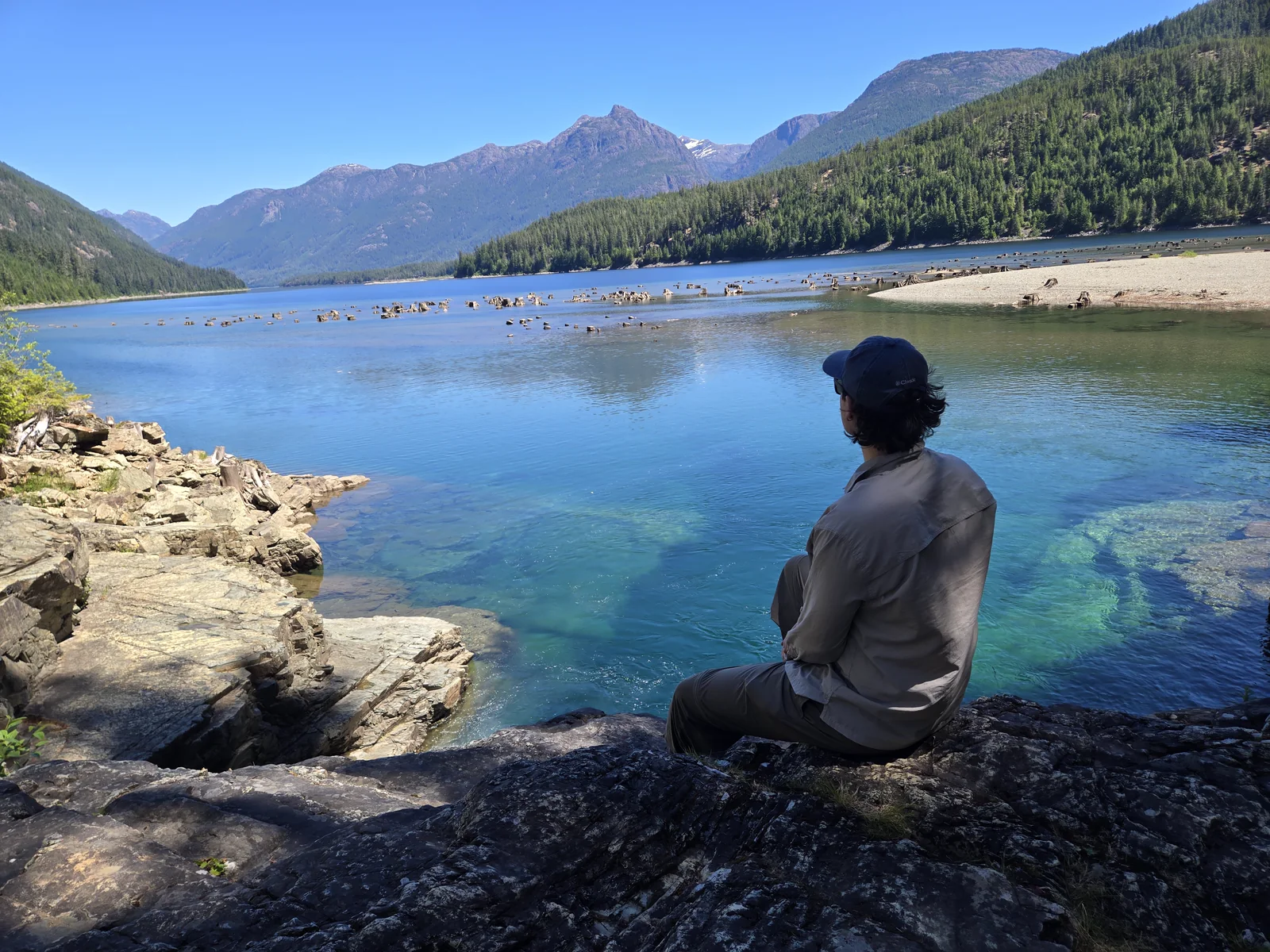 Nathan sitting beside a clear mountain lake on Vancouver Island